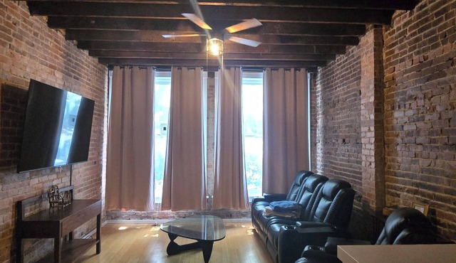 Large 1-bedroom apt with tall ceilings, brick walls, large tv, modern bathroom